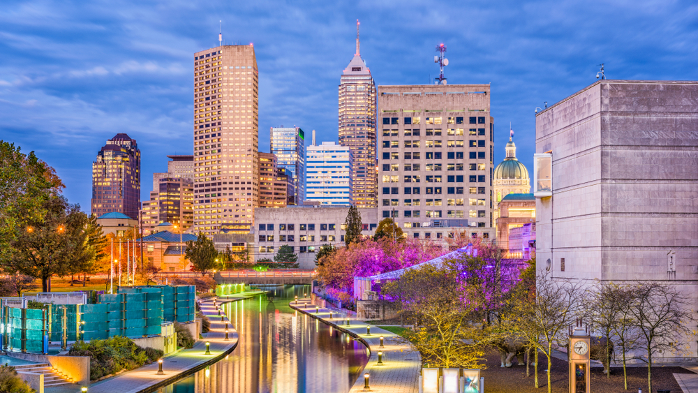 Indianapolis skyline at sunset with a canal in front.