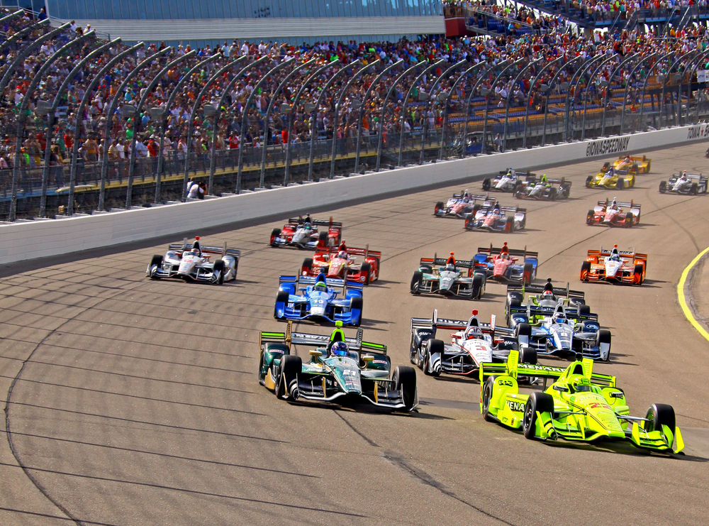 Cars racing around the track at the Indianapolis Motor Speedway.