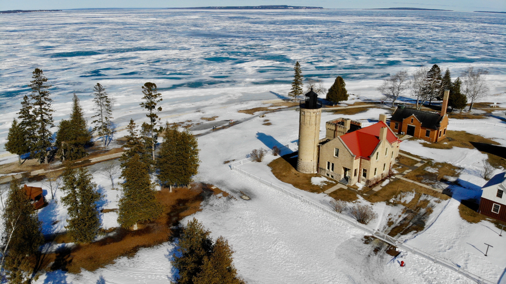 aerial photo of beige house with red roof in winter with snow