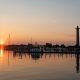 sunrise over marina with boats and monument
