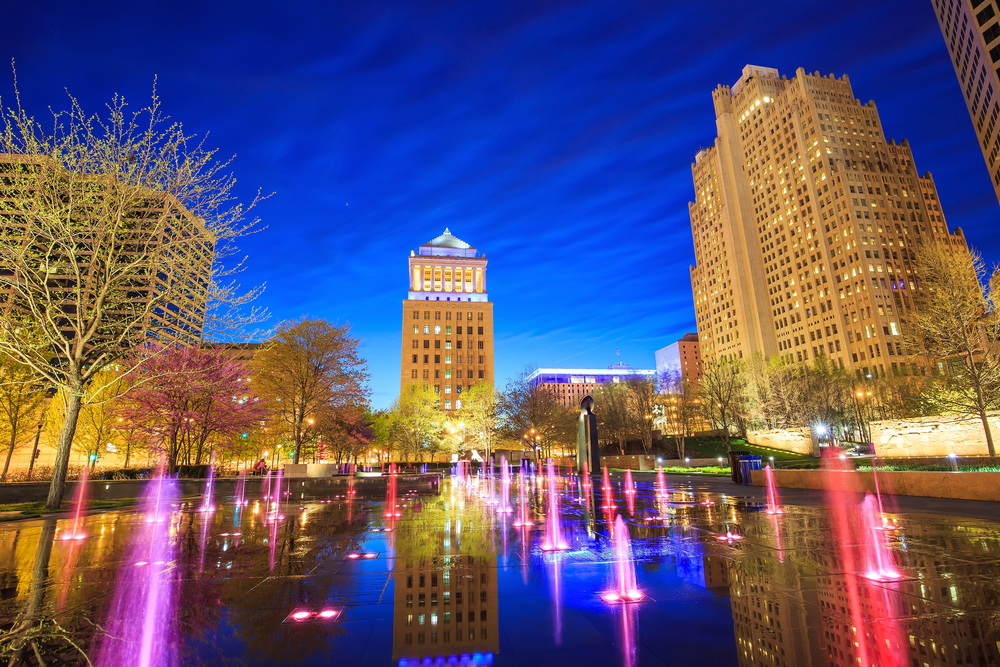 The lit up, colorful fountains at Citygarden with skyscrapers in the background. This park is one of the best things to do in St. Louis.