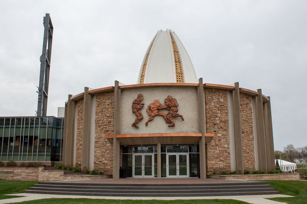 Circular building with stonework with bronze football figures above doorway. Steps in foreground. Weekend getaway in Ohio