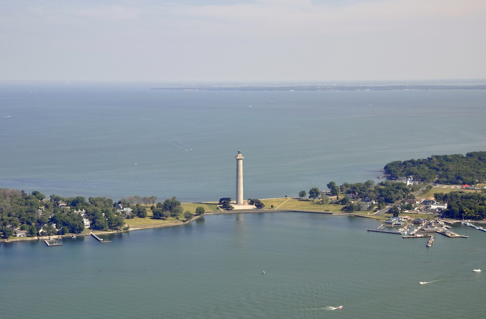 Aerial view of tall white monument with trees and land on either side, with water in background and foreground. Weekend getaways in Ohio.