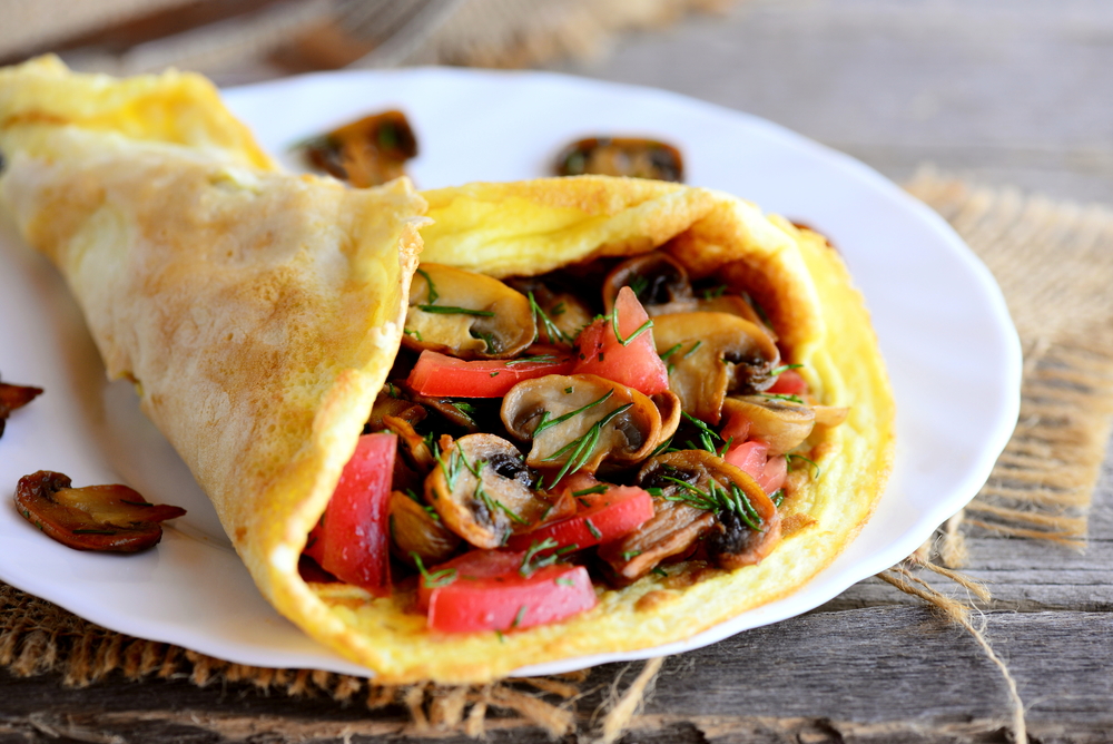 Omelet filled with mushrooms and tomatoes