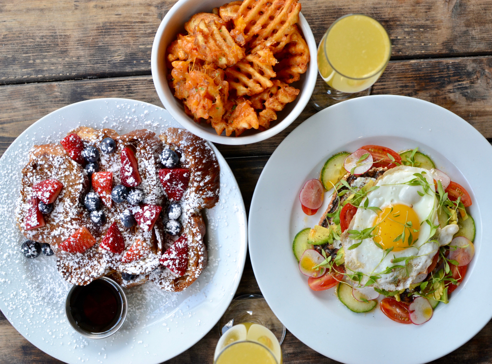 Berries on toast with egg and avocado on toast and some waffle fries