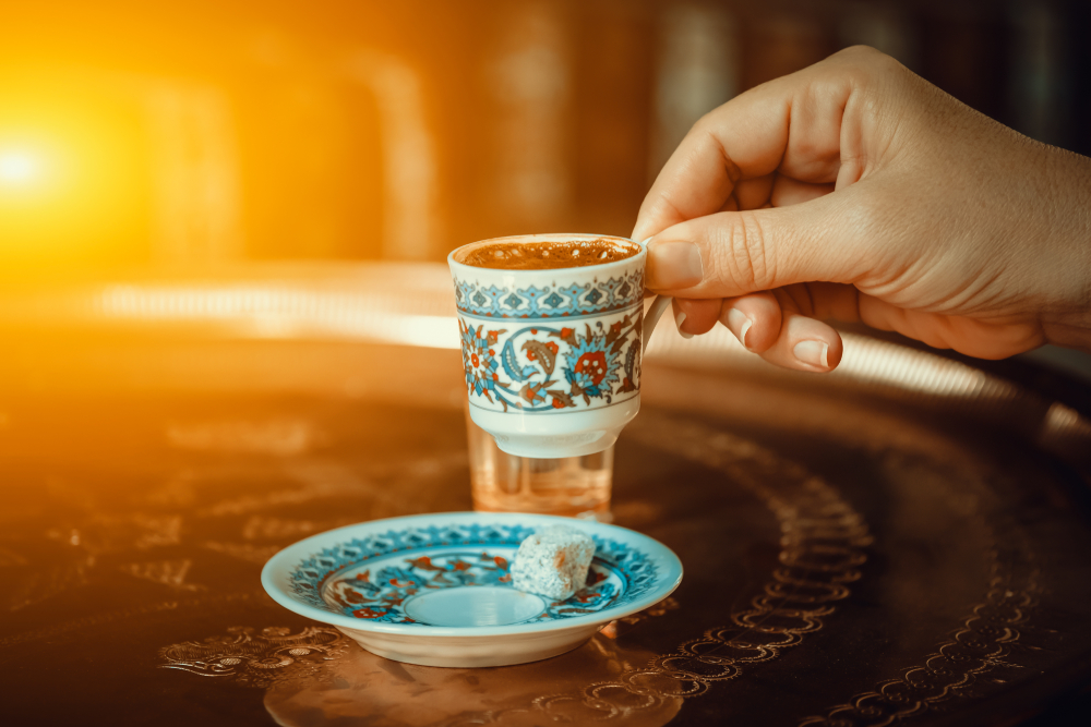 Women holding a Turkish coffee in a decorated cup in an article about breakfast in St Louis