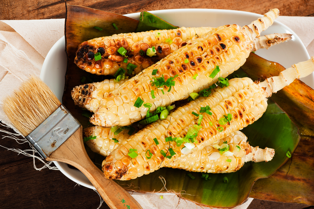 corn on the cob on a plate brushed with butter