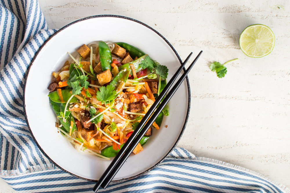 A tofu stir fry dish on a table with a blue napkin