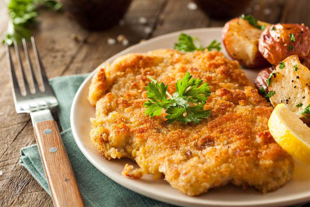 Homemade Schnitzel on a plate with a side of potatoes in an article about restaurants in Appleton Wisconsin.