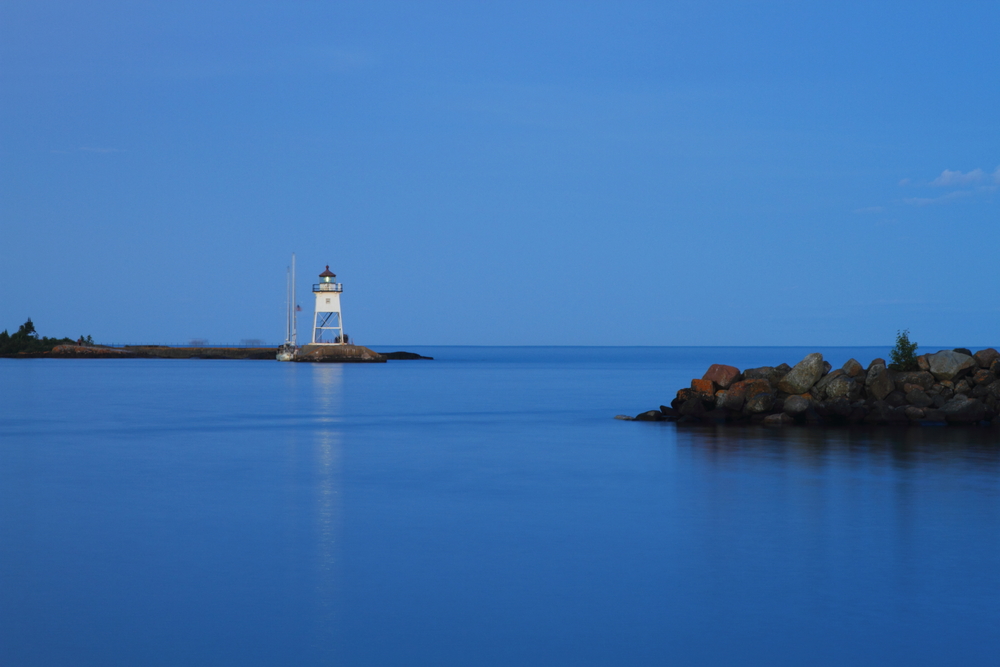 Lighthouse on an outcrop in the sea at nighttime