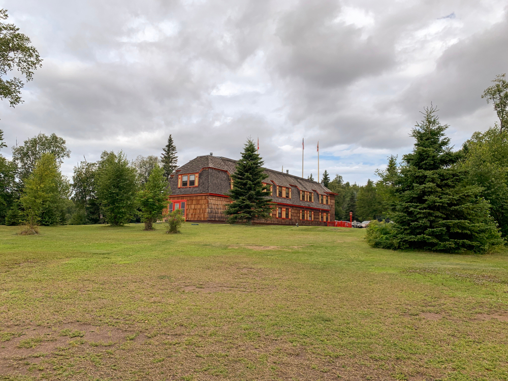 Green expanse with trees and a rustic brown wooden lodge in the background in an article about Things to Do in Grand Marais