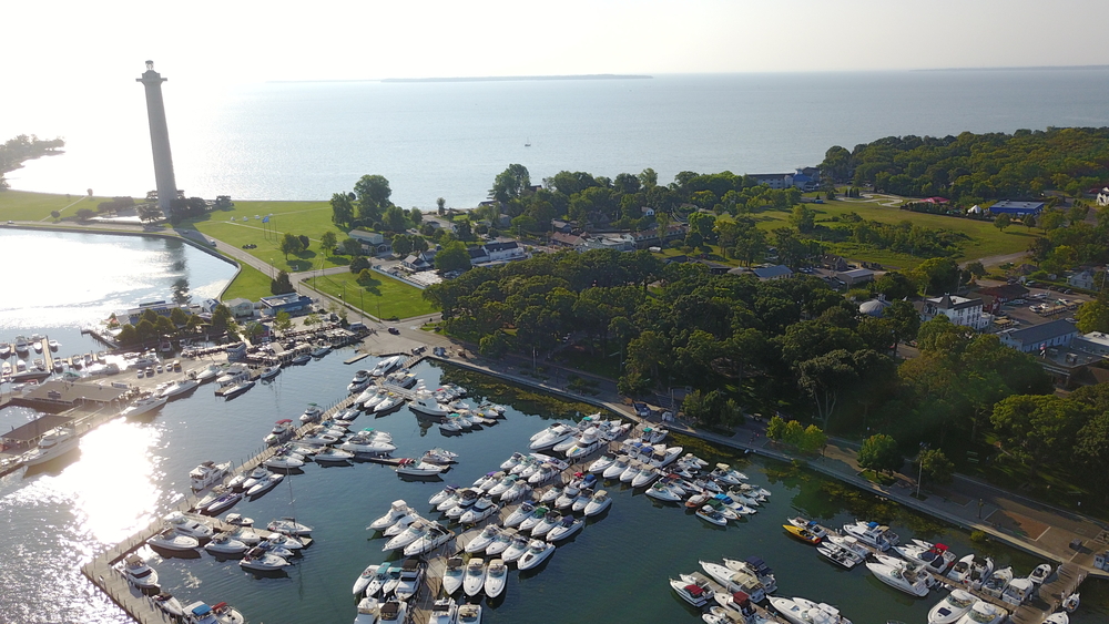 An aerial view of Put in Bay showing boats in the harbour and a monument in the background in an article about things to do in Put-in-Bay