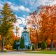 White lighthouse surrounded by autumnal colored trees. co