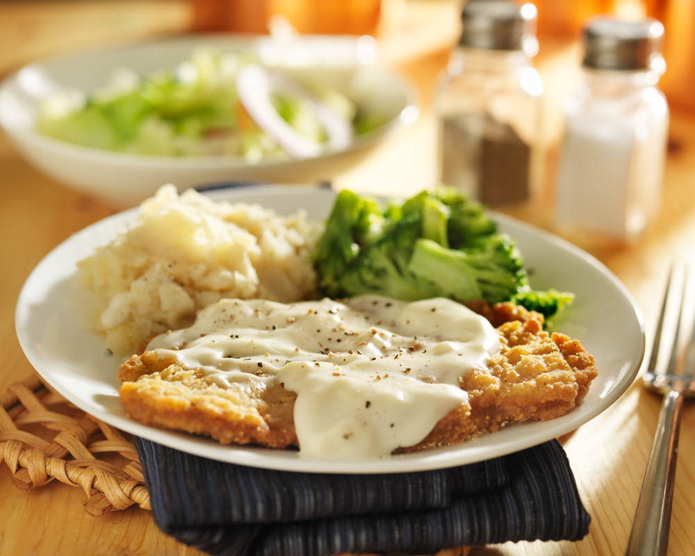 Chicken fried steak with mashed potatoes and broccoli.