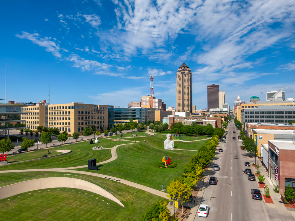 Aerial view of downtown Des Moines, Iowa, with a park and skyscrapers in the distance.