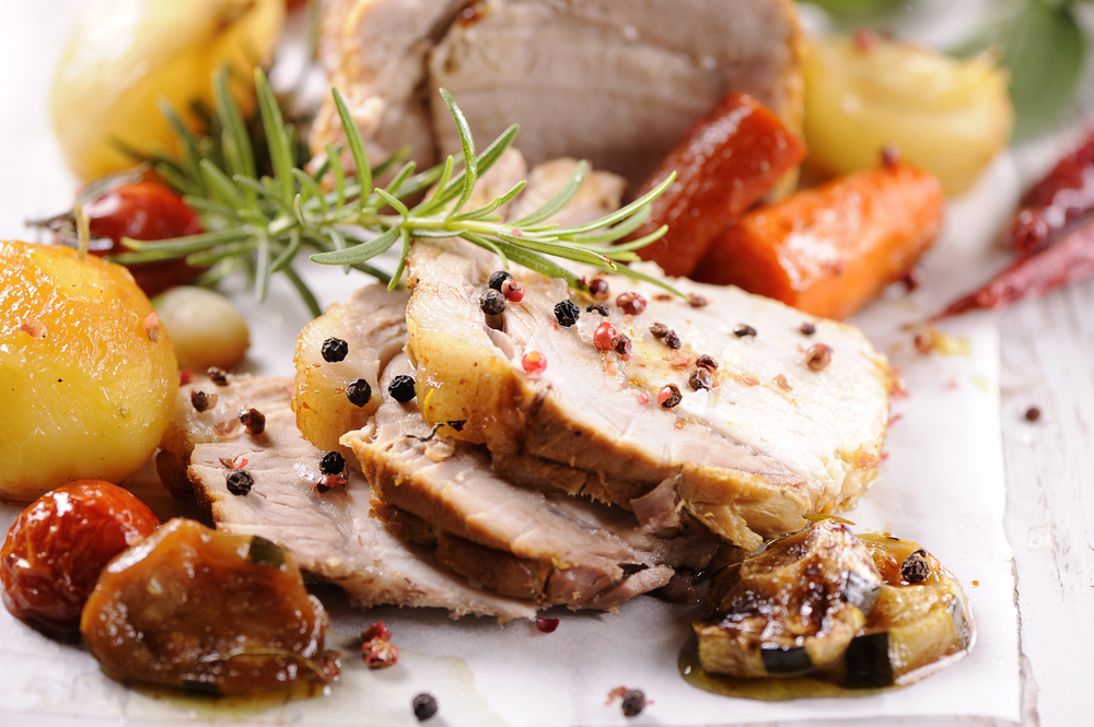 Close-up of seasoned pork tenderloin with roasted vegetables served at one of the epic restaurants in Des Moines.