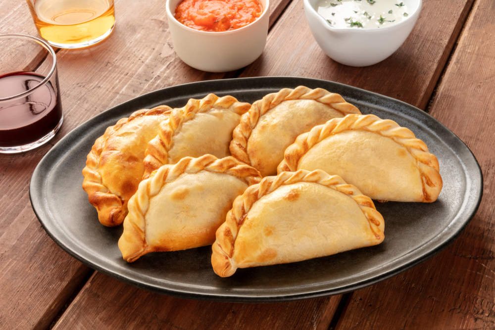 Plate of empanadas with bowls of sauces. Served at one of the best restaurants in Des Moines Iowa.