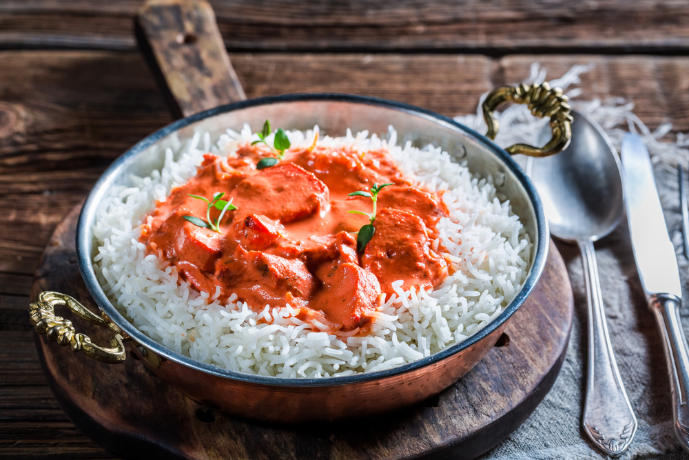 Tikka Masala with rice in a bowl on a wooden table