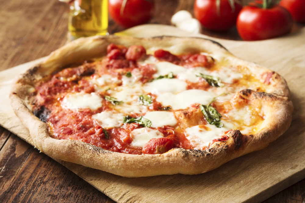 Fresh homemade vegetarian pizza on a wooden board in an article about restaurants in Branson