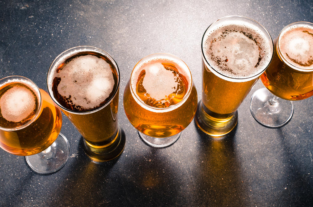 Beer in several types of glasses on dark table.