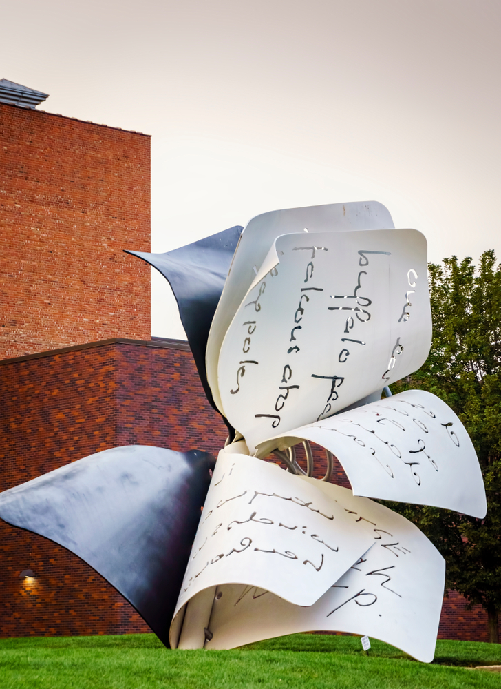 A large outdoor sculpture that looks like book pages flapping in the wind. It is made of metal and has words carved into it. It is outside the Sheldon Art Museum, one of the best things to do in Lincoln. 