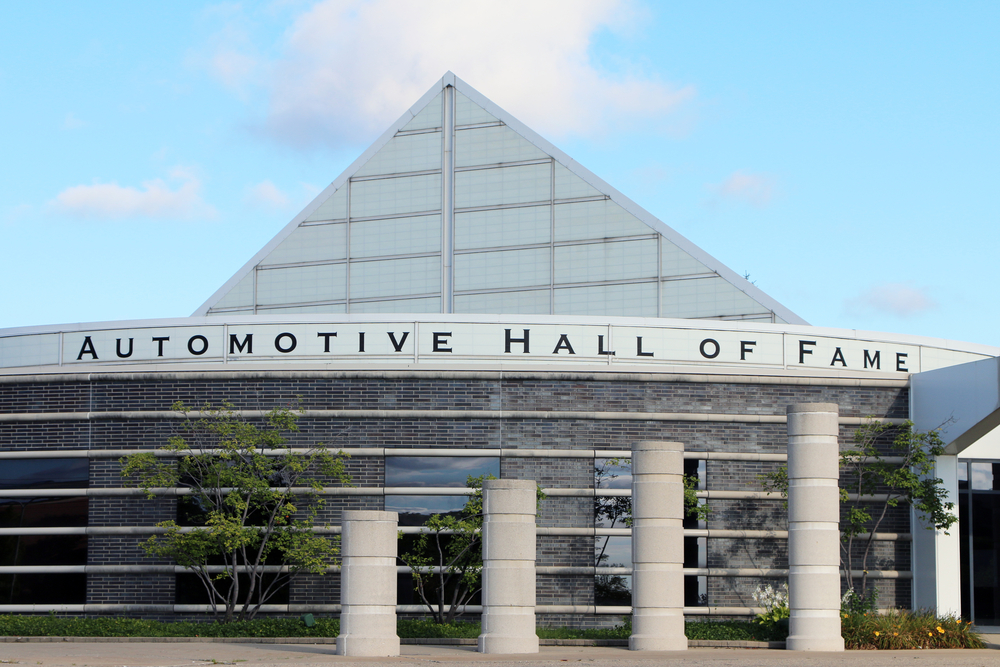 The exterior of the Automotive Hall of Fame, one of the best things to do in Detroit. It is a modern looking building with a large pyramid shape in the front. 