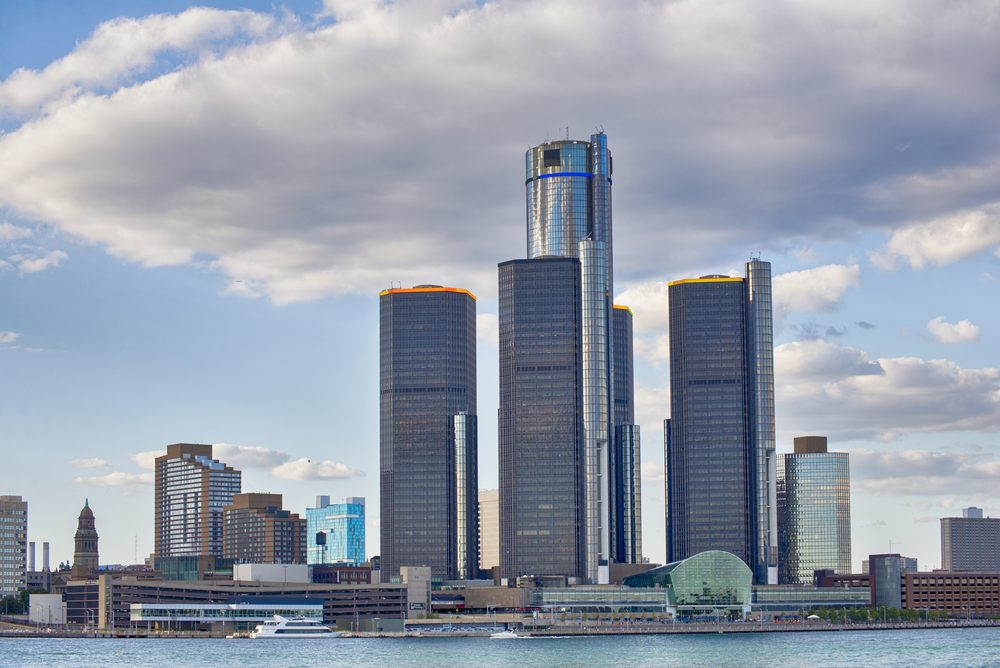 The view of the General Motors Renaissance Center from across the Detroit River in Canada. It is a large modern skyscraper with four separate buildings. 