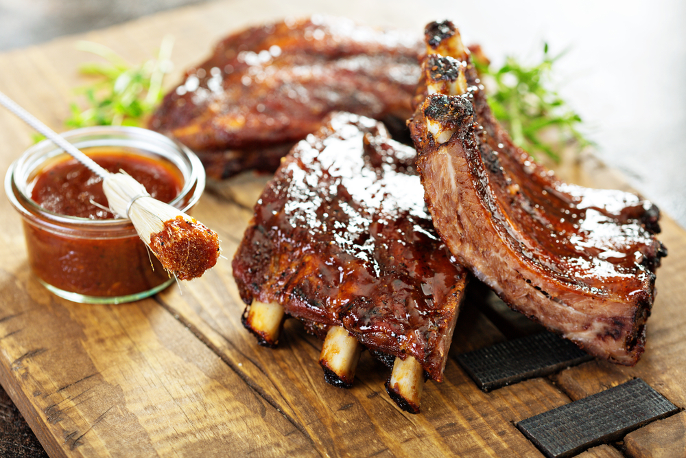 BBQ ribs on a wooden board in an article about restaurants in Kansas City