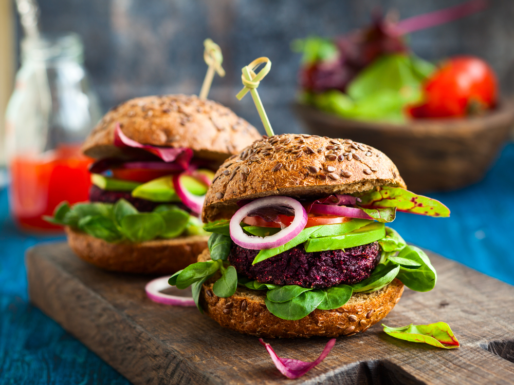 Beet Burger with salad with wholegrain bun is served up at one of the best plant-based restaurants in Kansas City MO.