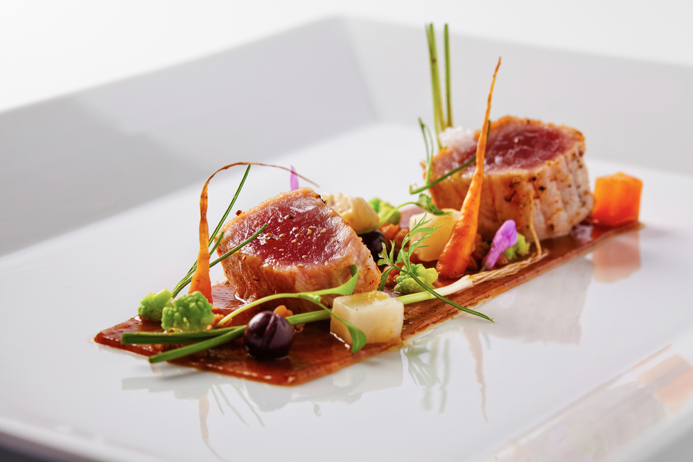 A small fine dining plate with two small pieces of tuna and vegetable in an article about restaurants in Kansas City