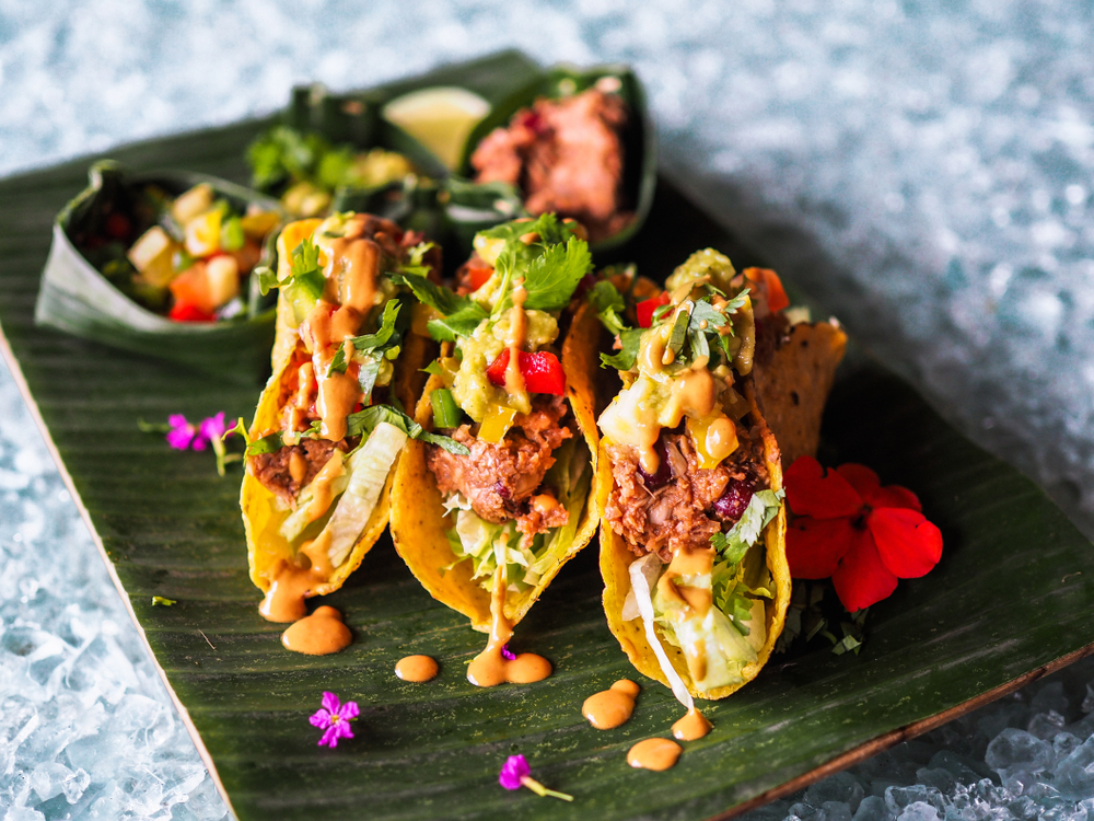 Jackfruit tacos with lettuce and salad on a green plate