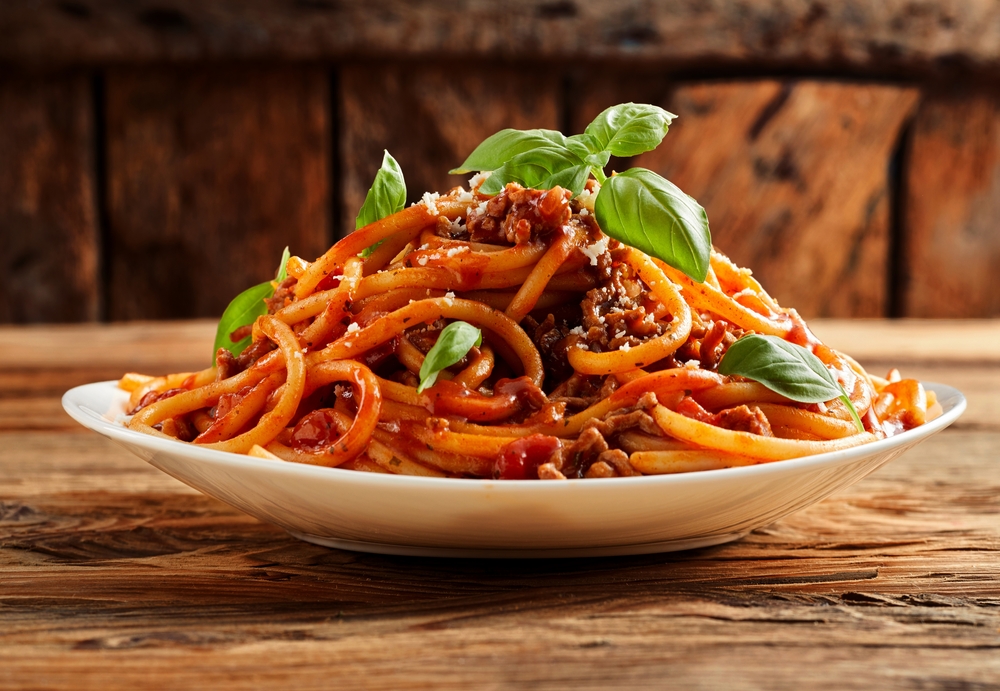 A heap of spaghetti Bolognese on a palate with a garnish on top served from a top Kansas City restaurant.