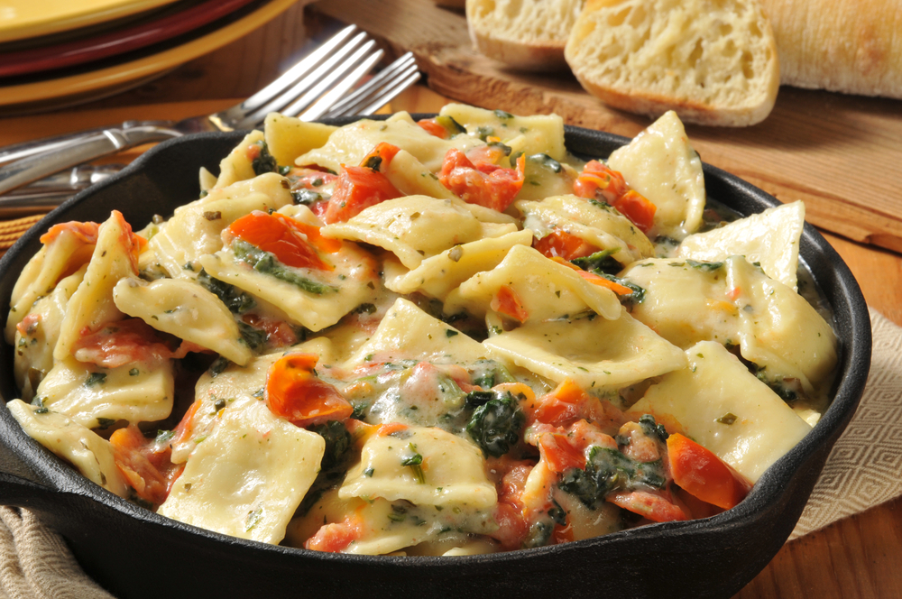 Ravioli in a dish with tomatoes and olives in an article about restaurants in Kansas City