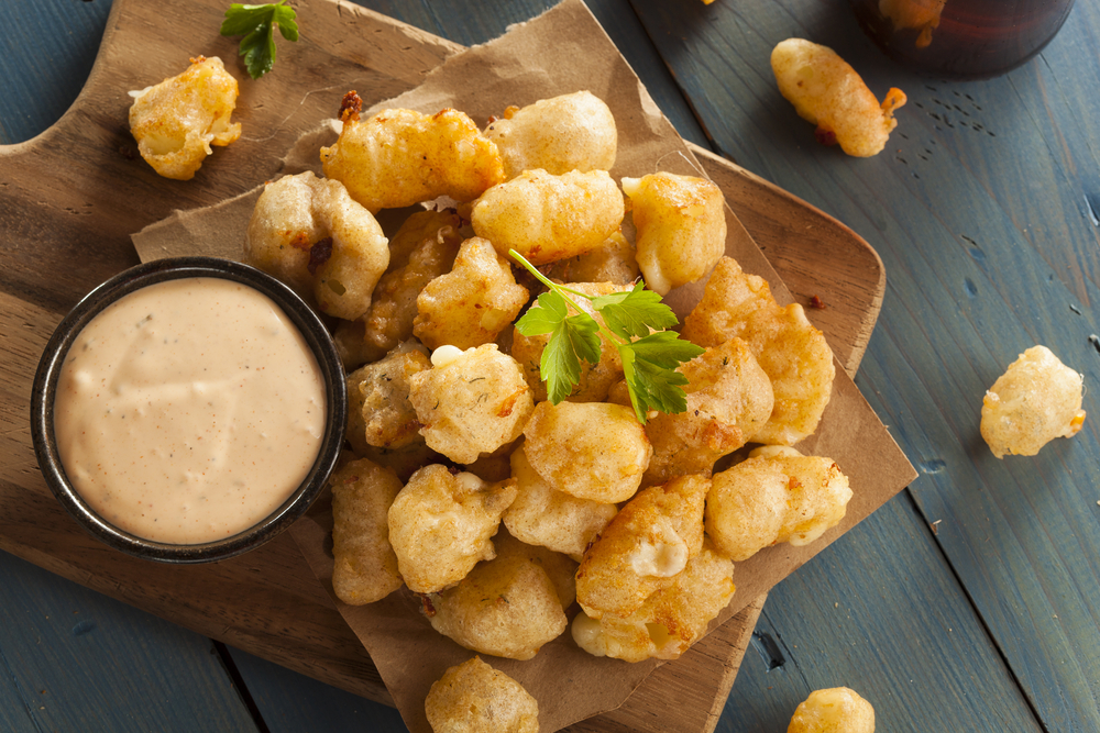 cheese curds served with a dip on a wooden plank restaurants in green bay