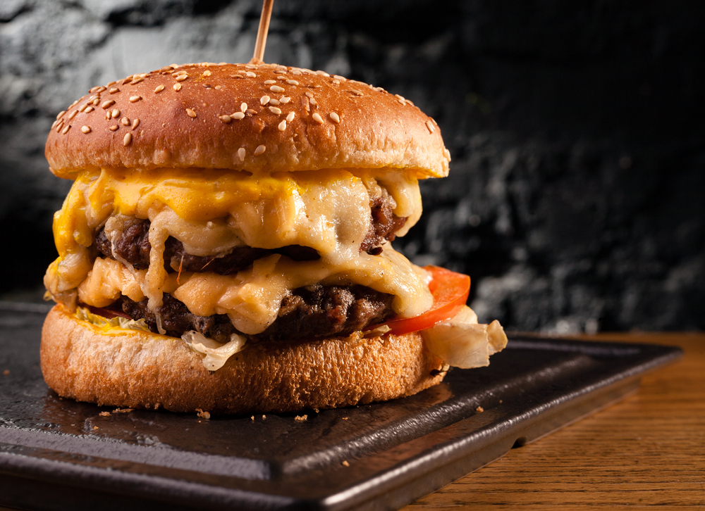 A cheeseburger with lots of cheese on a plate at one of the best restaurants in Minneapolis