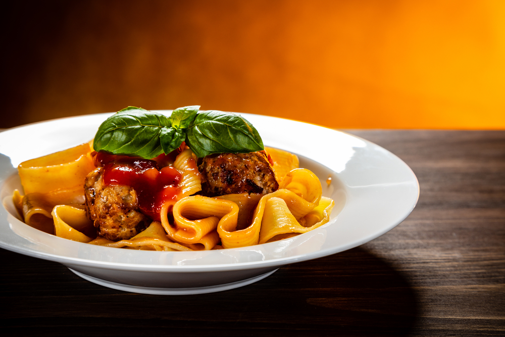 Pasta and meatballs in a dish on a wooden table