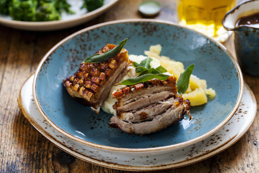 pork belly on a plate with mashed potatoes