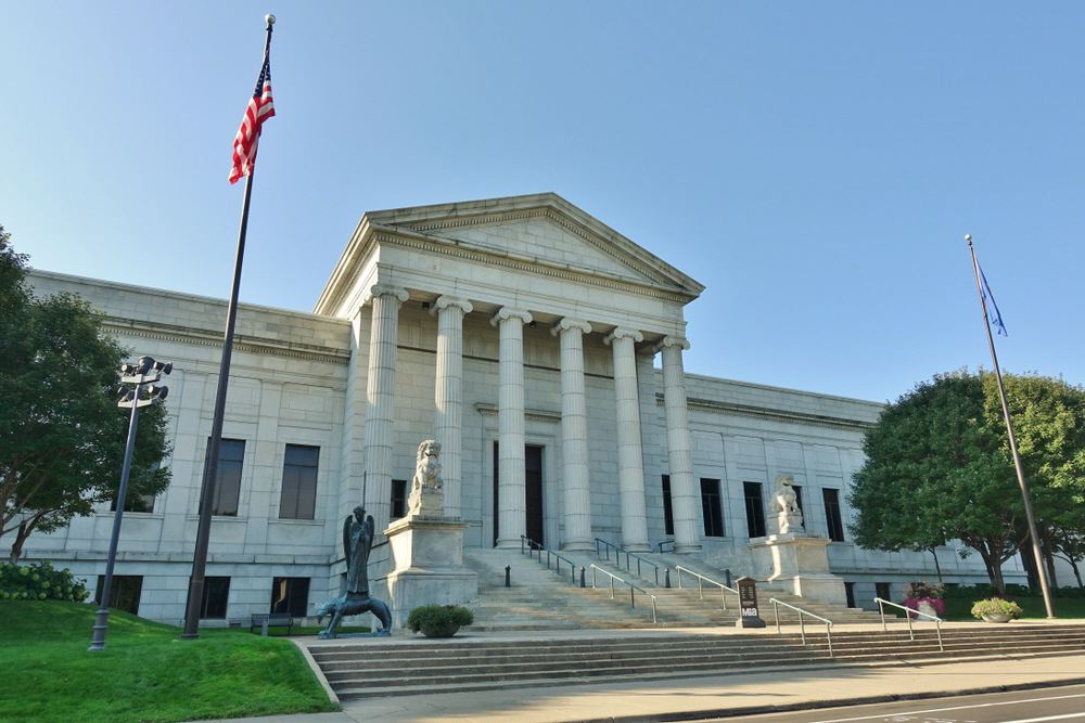 Minneapolis Institute of Art a white building with pillars, steps and American flags. One of the things to do in Minneapolis p