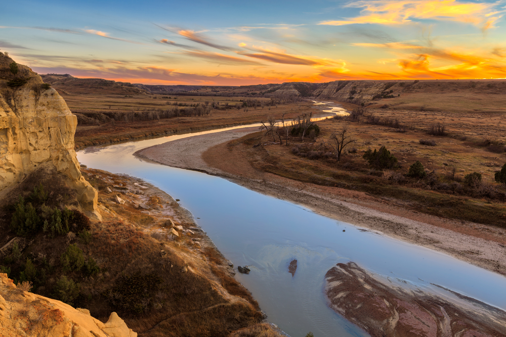 River flowing from the middle of plains during sunset
