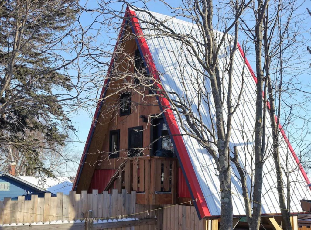 A-frame cabins in Minnesota with white metal roof trimmed in red.