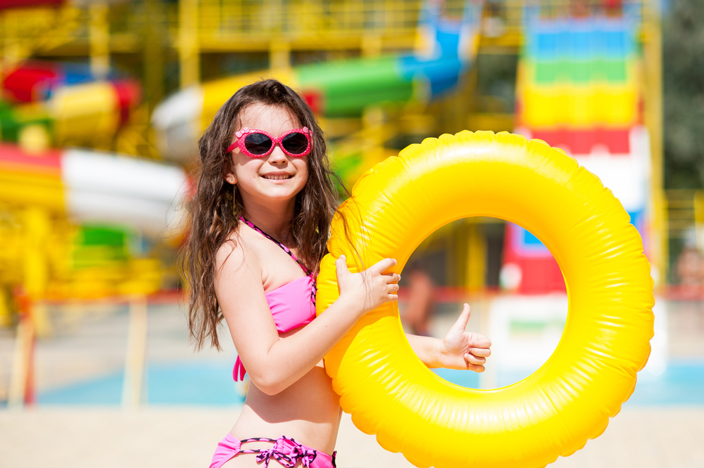 A girl holding a yellow inner tube at a waterpark in Ohio.