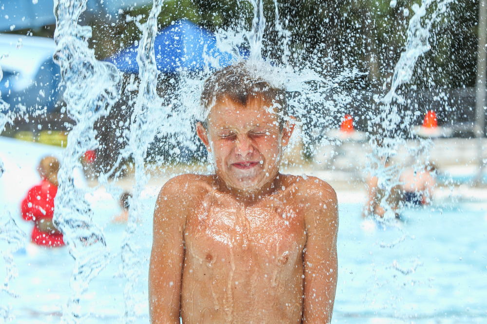 A boy under a spray of water.
