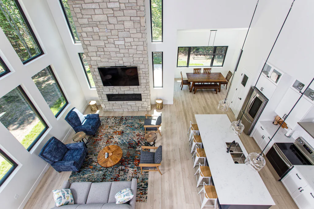 Aerial view of a stylish room with huge windows and a large white table One of the beautiful cabins for rent in Door County