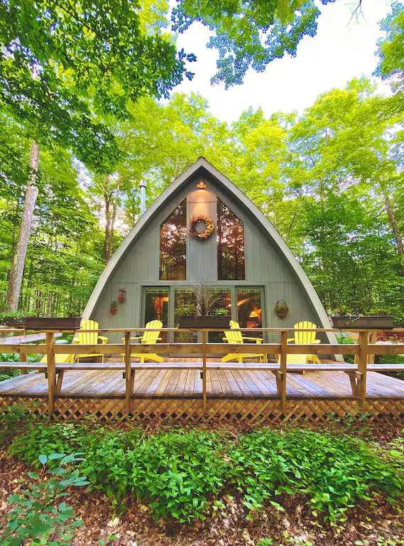 A large grey cabin with a large front porch in an article about cabins in Door County