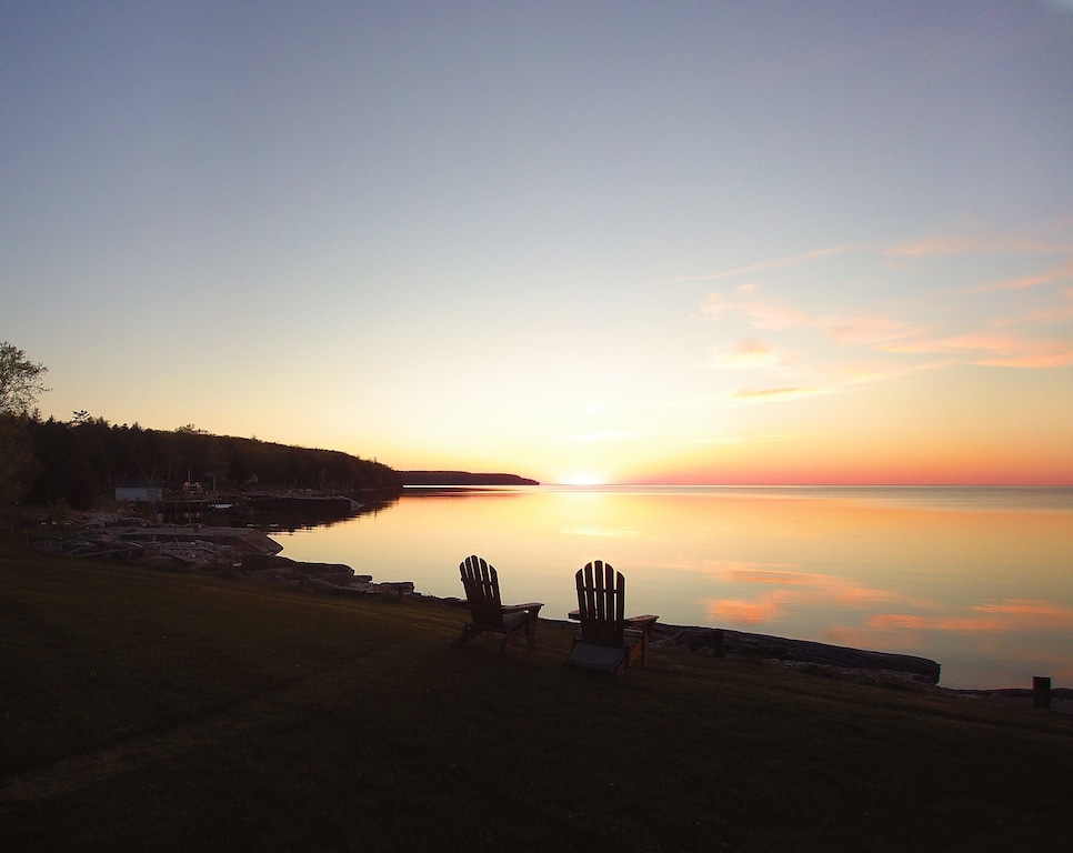 Two chairs looking out over the lake at sunset