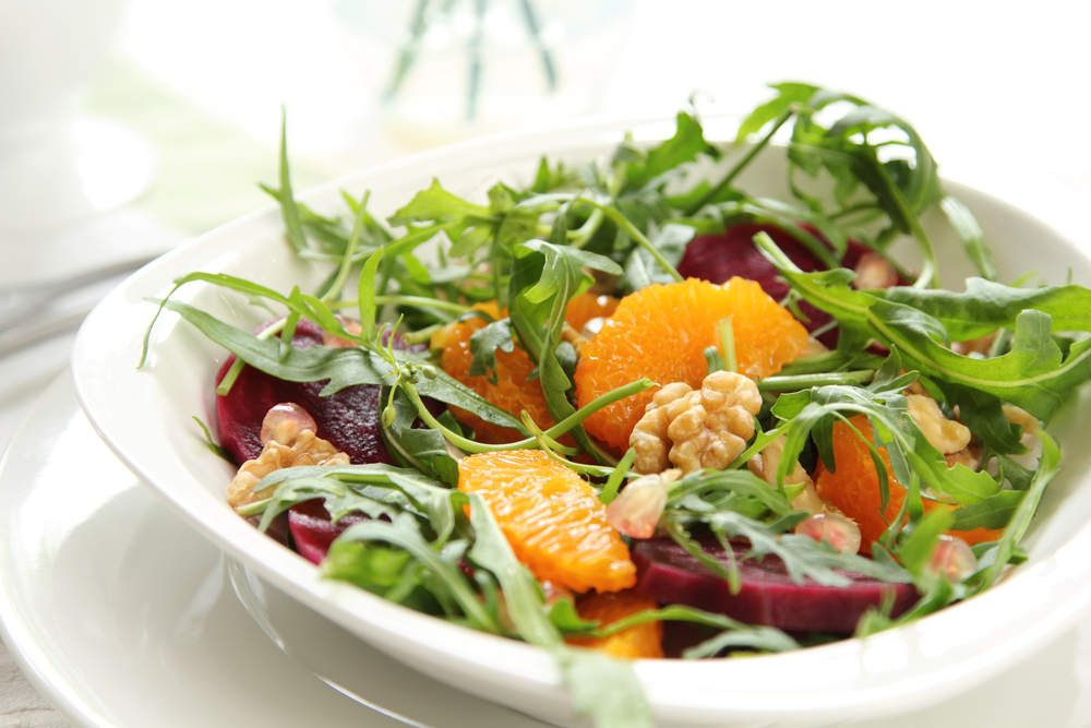 A salad of rocket oranges and beetroot in a white bowl with fresh green lettuce served at a Kalamazoo restaurant