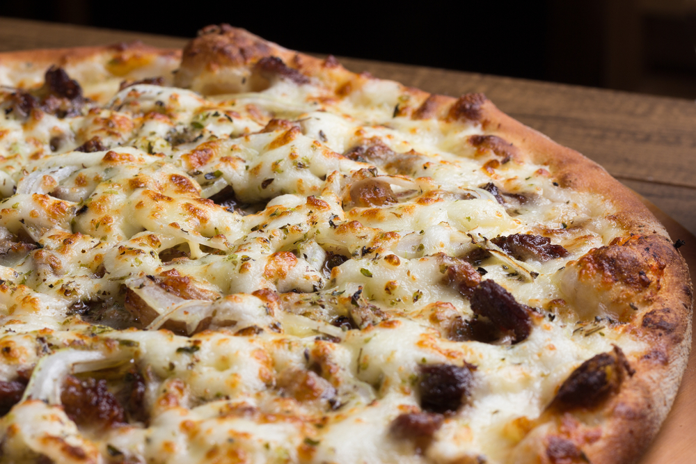 A close up of a pizza on a wooden board