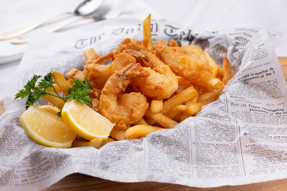 Shrimp and fries with lemon in a basket on a newspaper served at one of the restaurants in Marquette MI