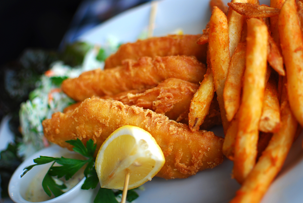 Fish and chips with coleslaw, lemon and tartare sauce on a plate in an article about restaurants in marquette mi