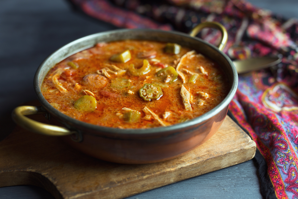 Gumbo in a metal dish on a wooden board in a article about restaurants in Marquette MI